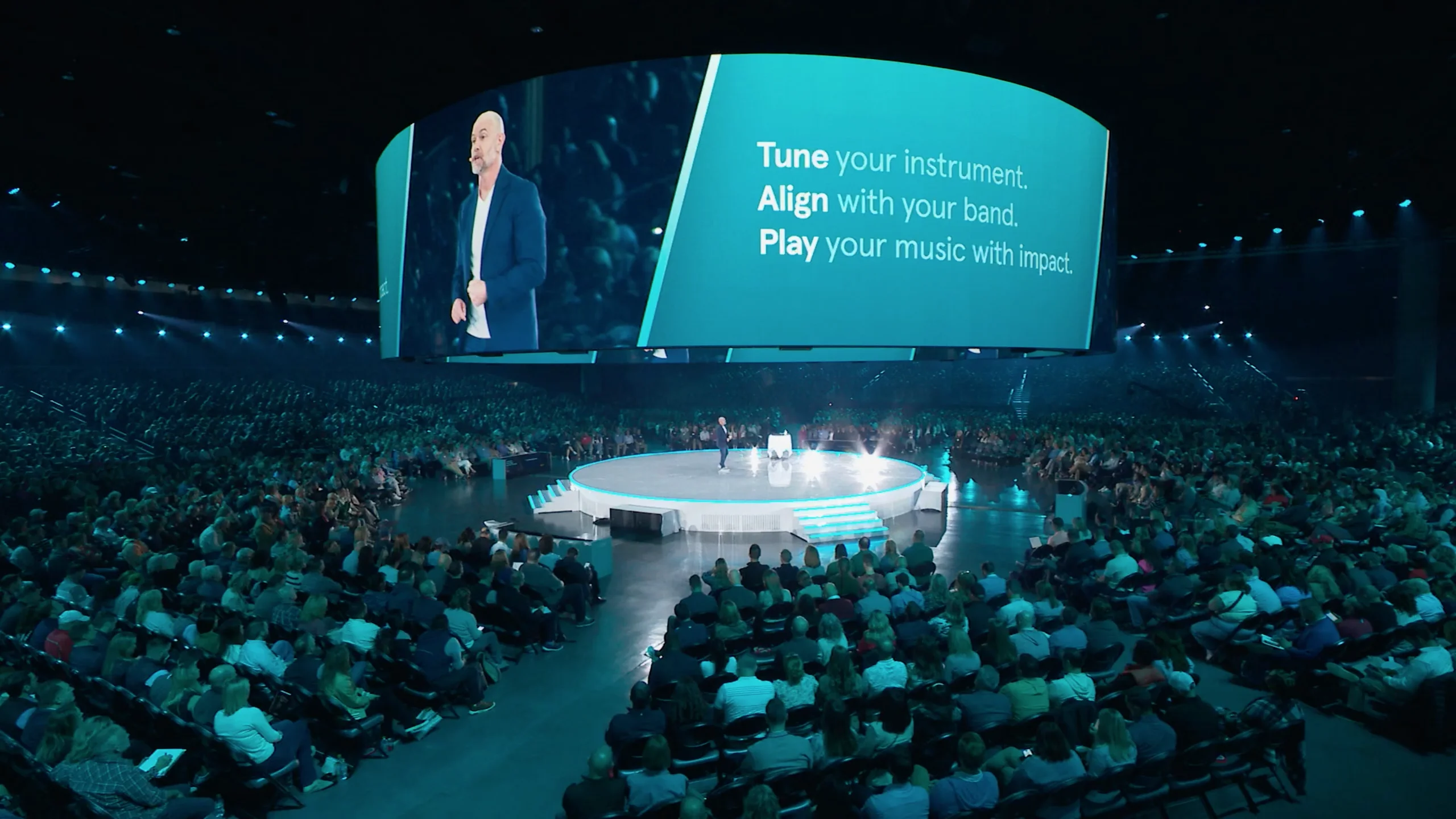Bronkar Lee delivering a keynote in a large arena
